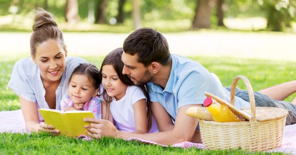 Family reading at a picnic.