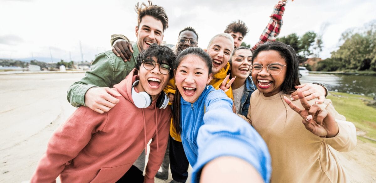 A group of young individuals smiling and posing together for a selfie, capturing a moment of joy and friendship.