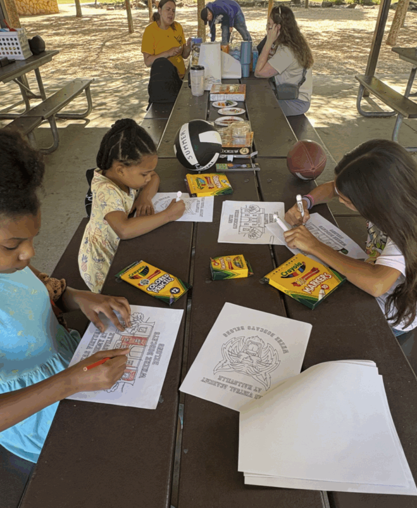 image of students coloring at a picnic table