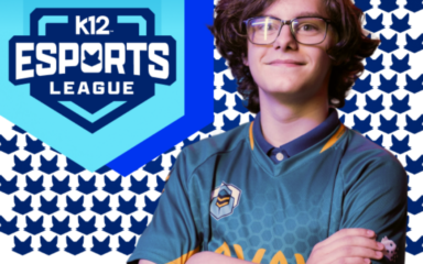 A person wearing a teal esports jersey stands with arms crossed in front of a patterned background featuring repeating blue fox-shaped icons. To the left, a large blue shield-shaped logo reads “K12 Esports League” with a stylized fox emblem above the text.